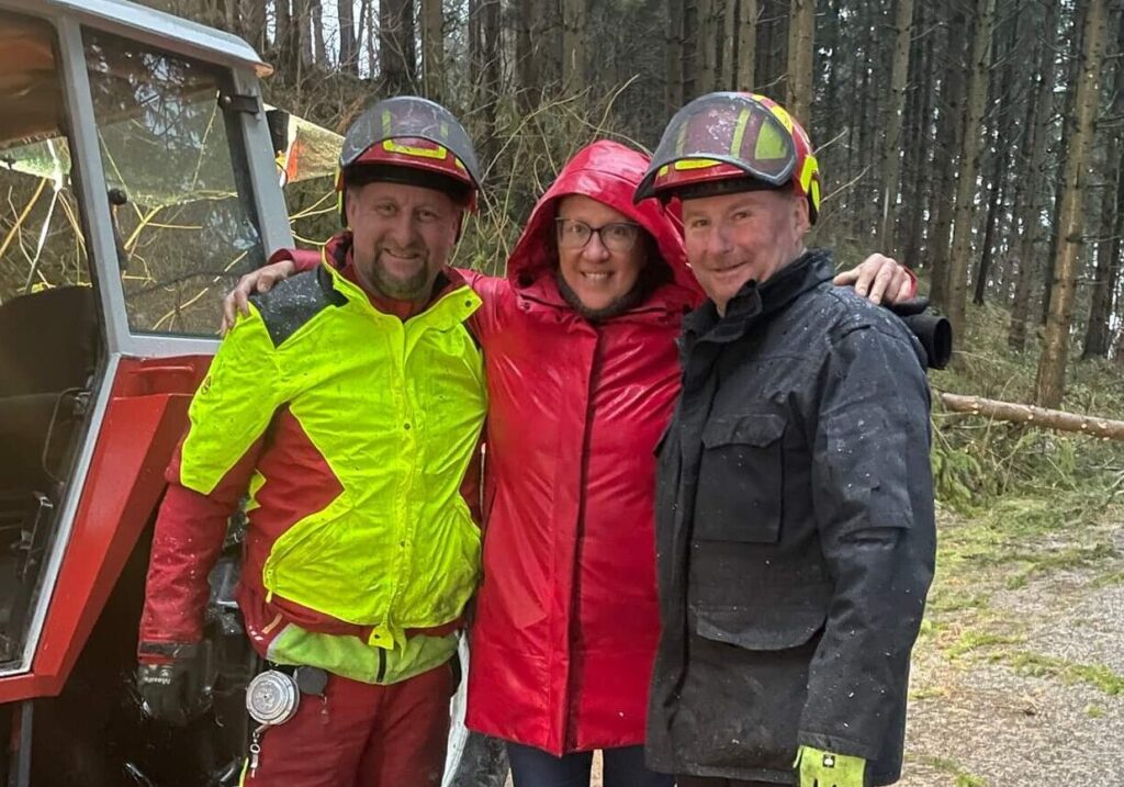 Drei Personen im Wald, Regenbekleidung.