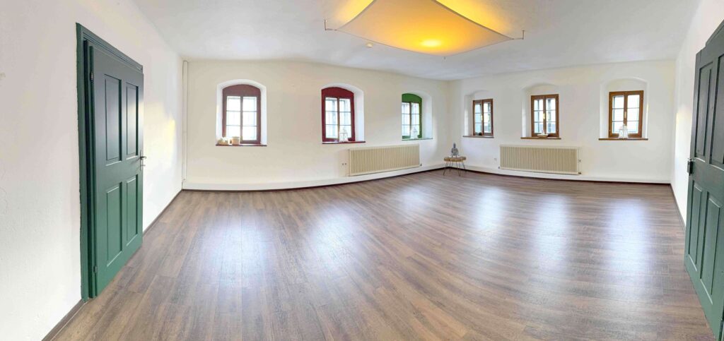 Heller Raum mit Holzfußboden und Fenstern