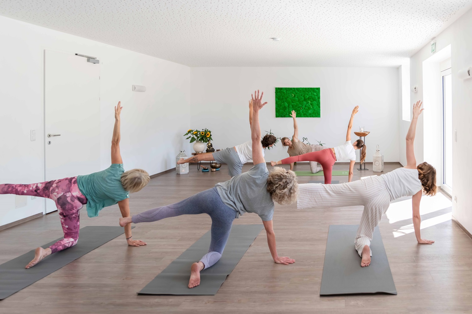 Gruppe macht Yoga in einem Raum.
