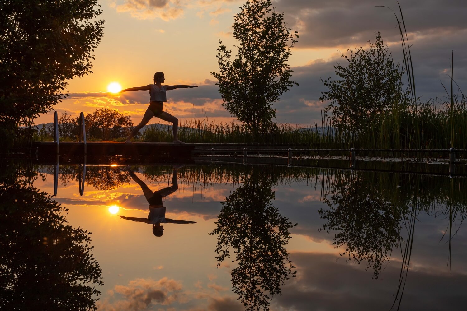 Yoga-Übung bei Sonnenuntergang am Wasser