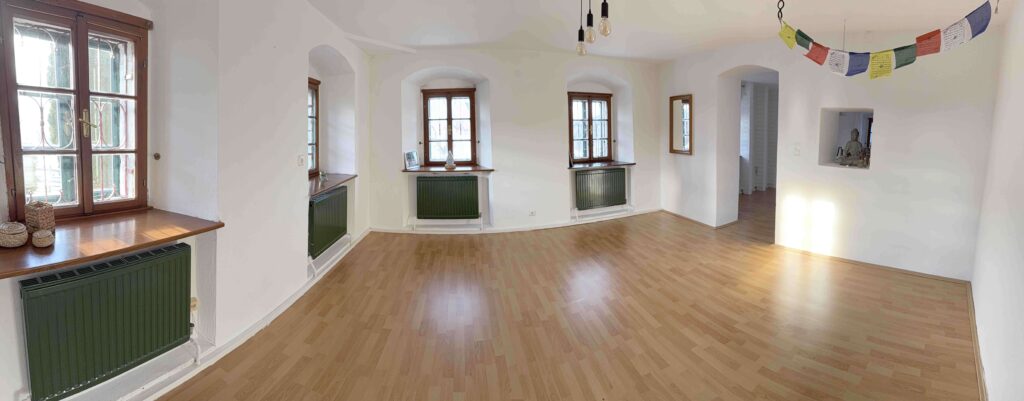 Heller Raum mit Holzfußboden und Fenstern