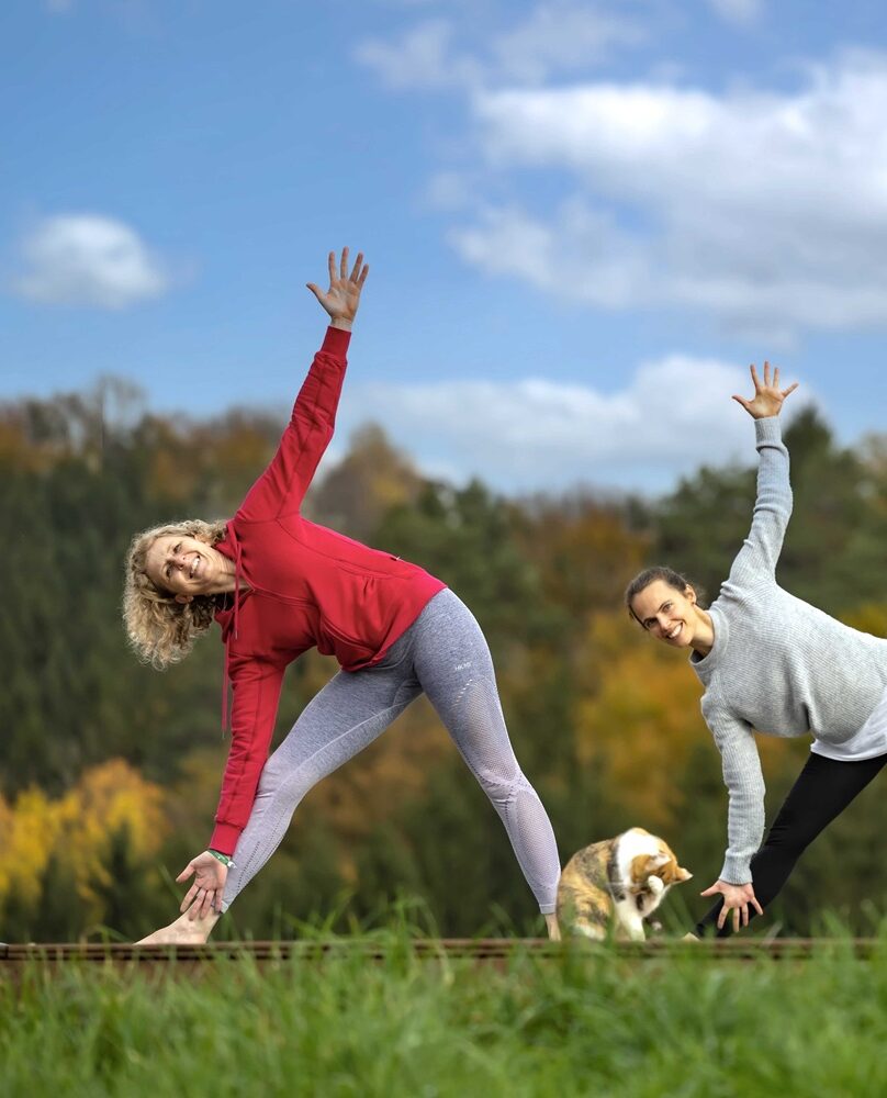 Drei Frauen praktizieren Yoga im Freien.