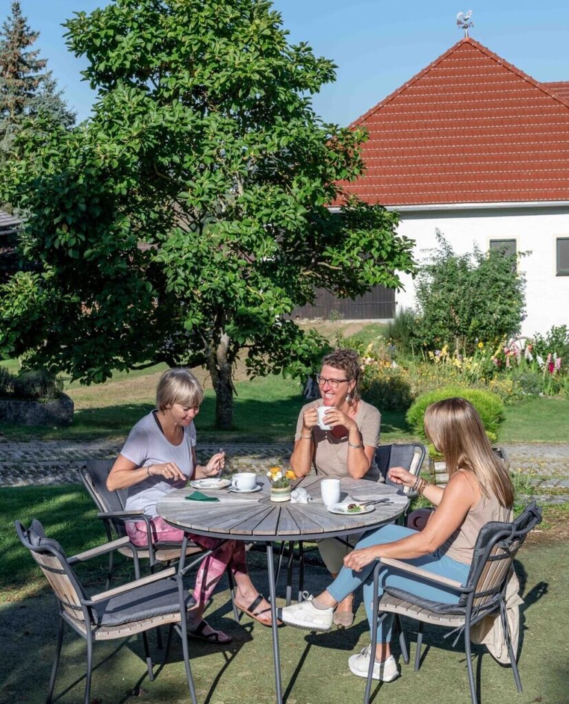 Drei Personen genießen ein Frühstück im Freien