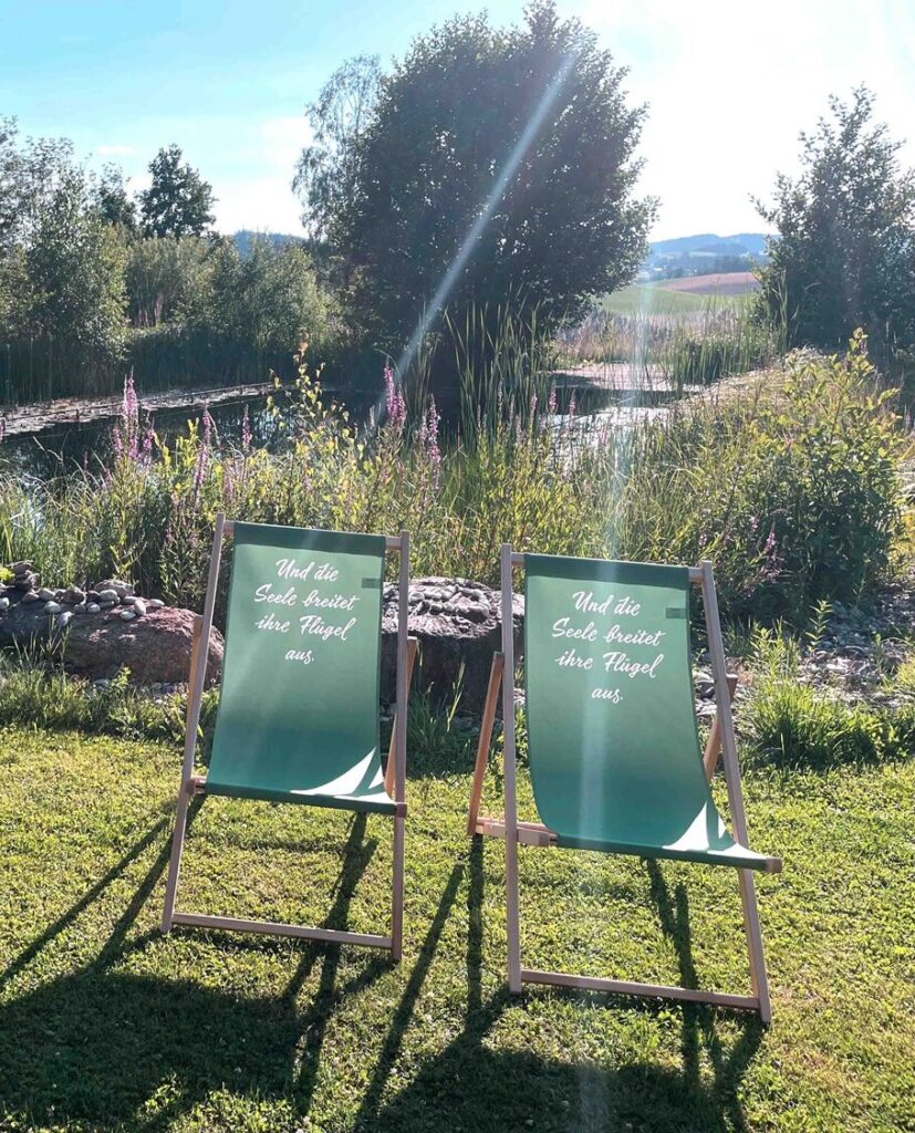 Zwei Liegestühle am Naturbadeteich.