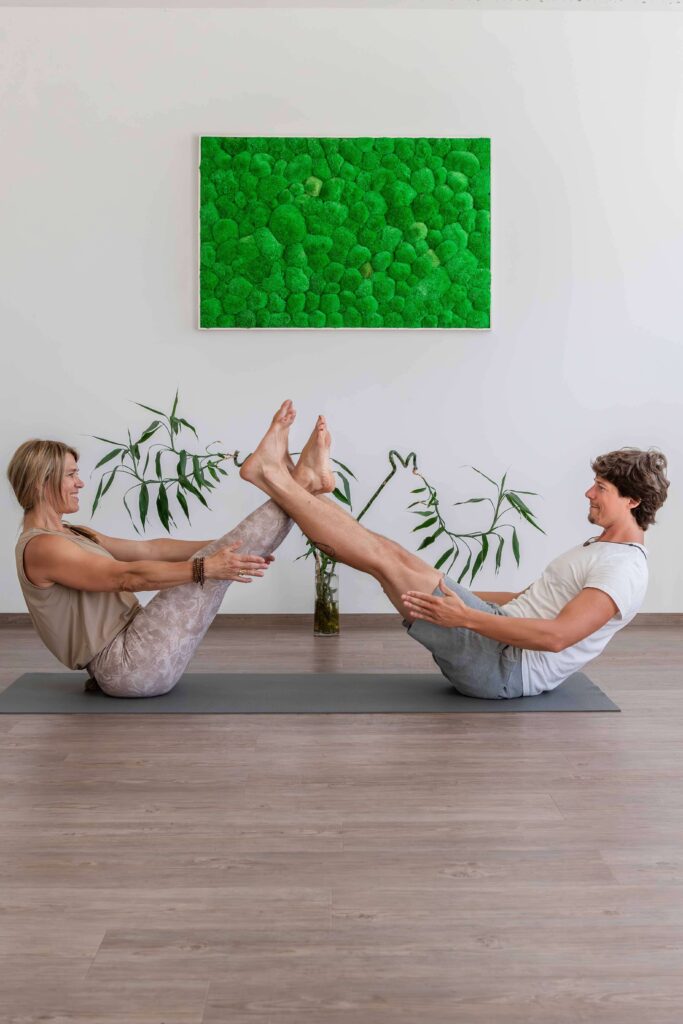 Zwei Personen machen Partner-Yoga-Übung