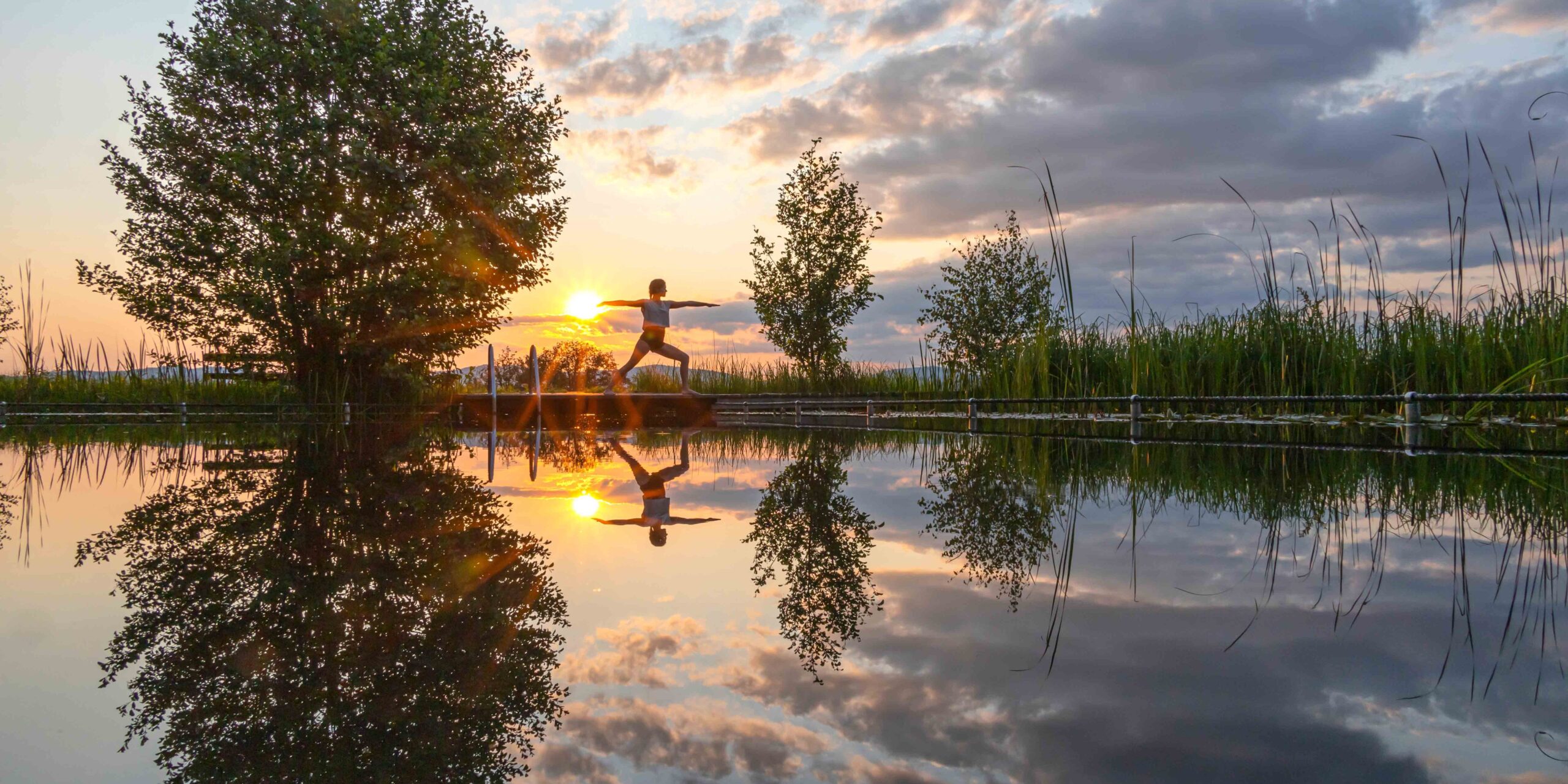 Yoga-Übung bei Sonnenuntergang am Teich