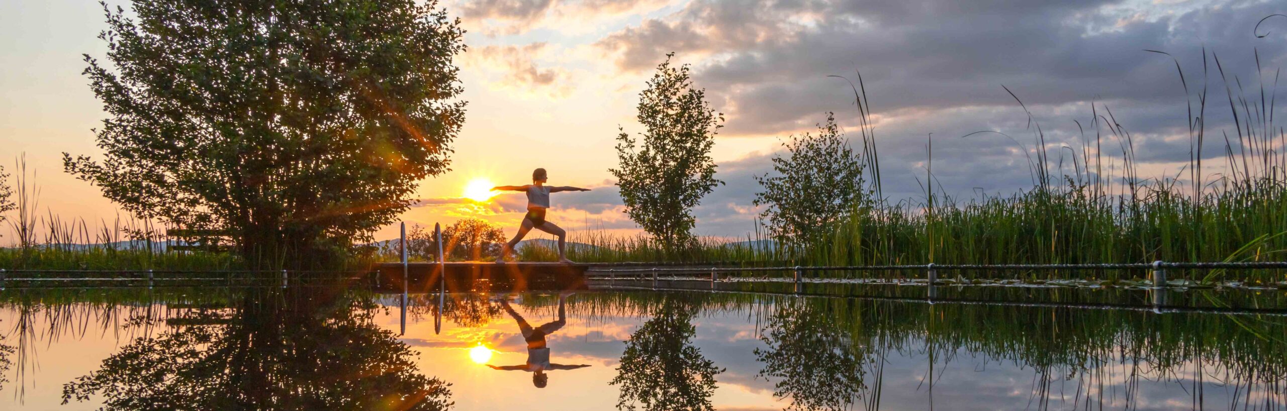 Yoga-Übung bei Sonnenuntergang am Teich