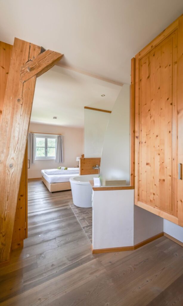 Helles Zimmer mit Holzdetails und Badewanne
