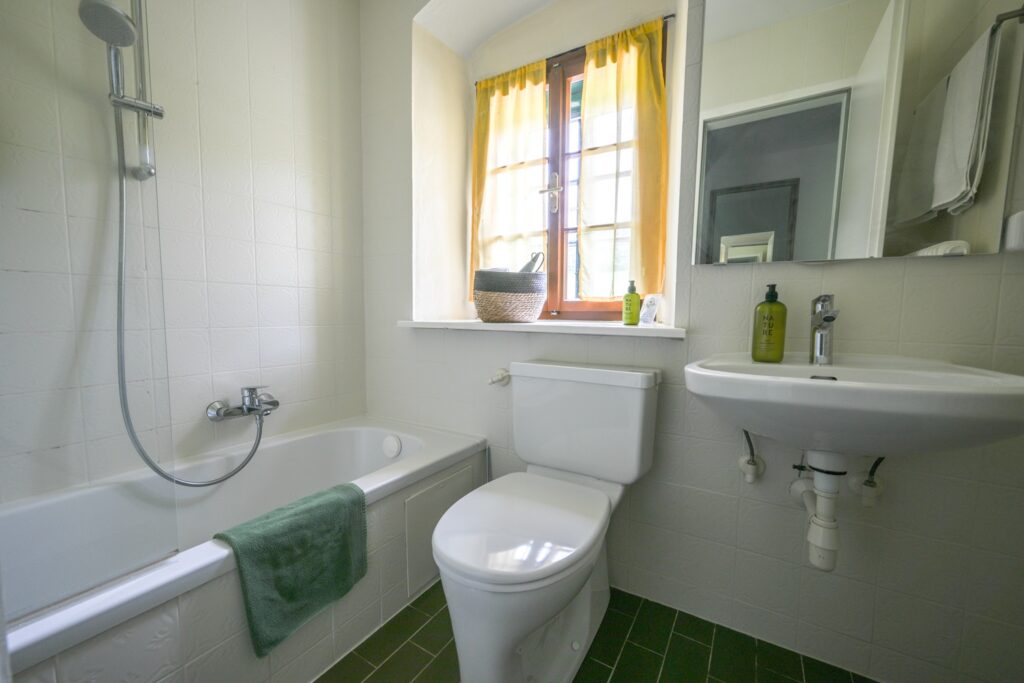 Helles Badezimmer mit Badewanne und Fenster