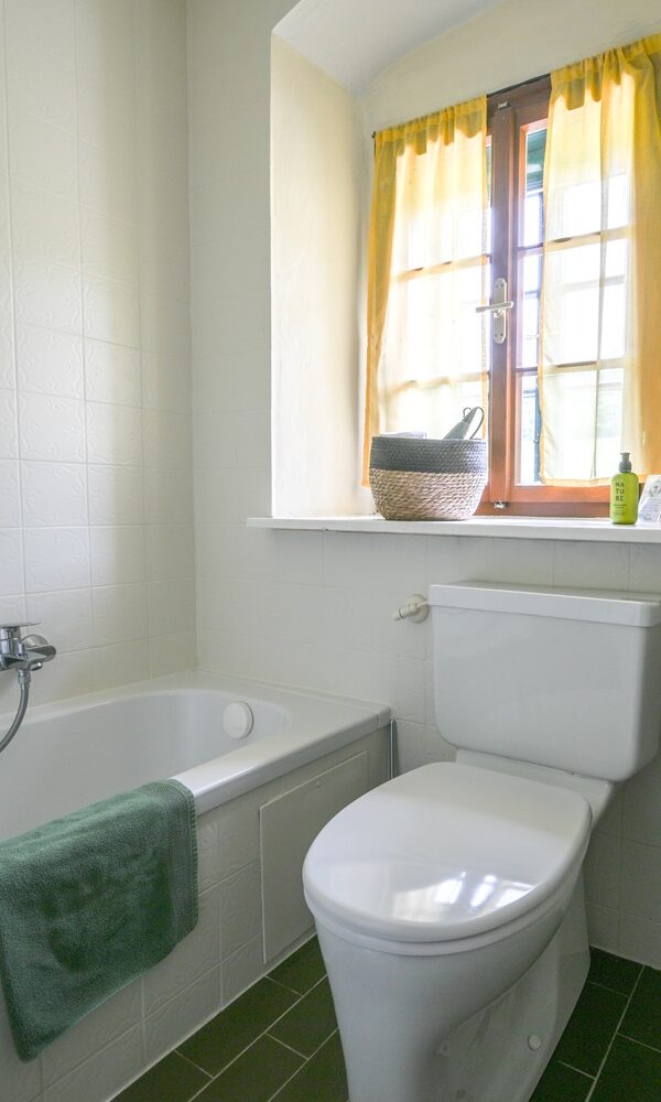 Helles Badezimmer mit Badewanne und Fenster