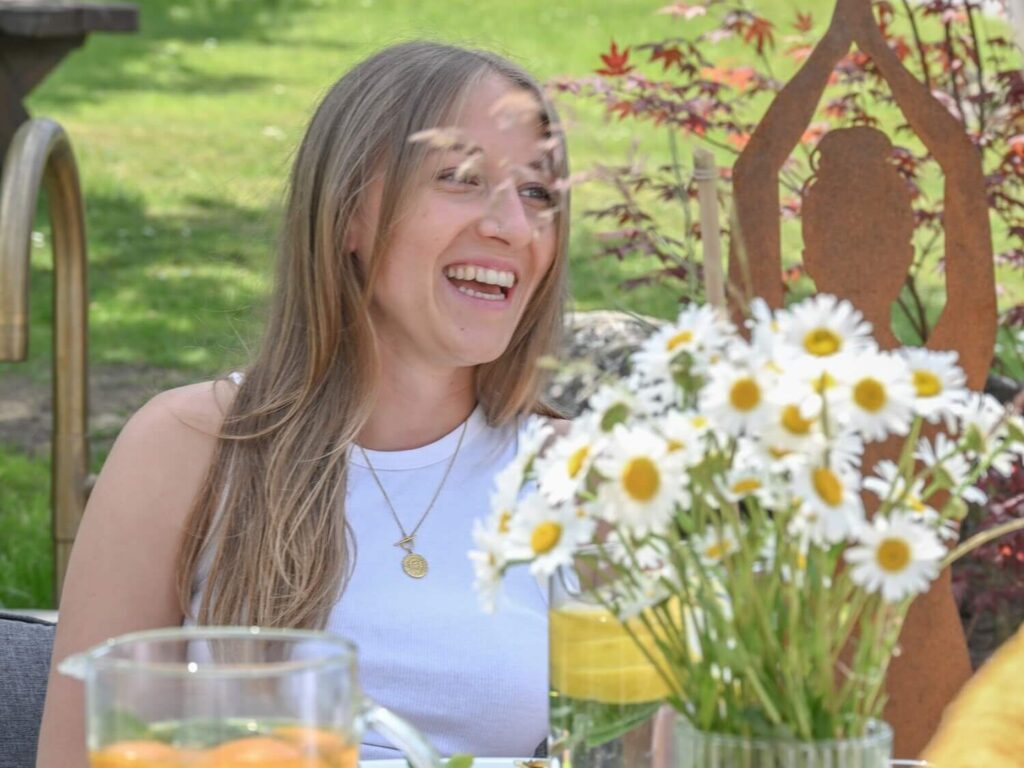 Lächelnde Frau mit Blumen und Essen