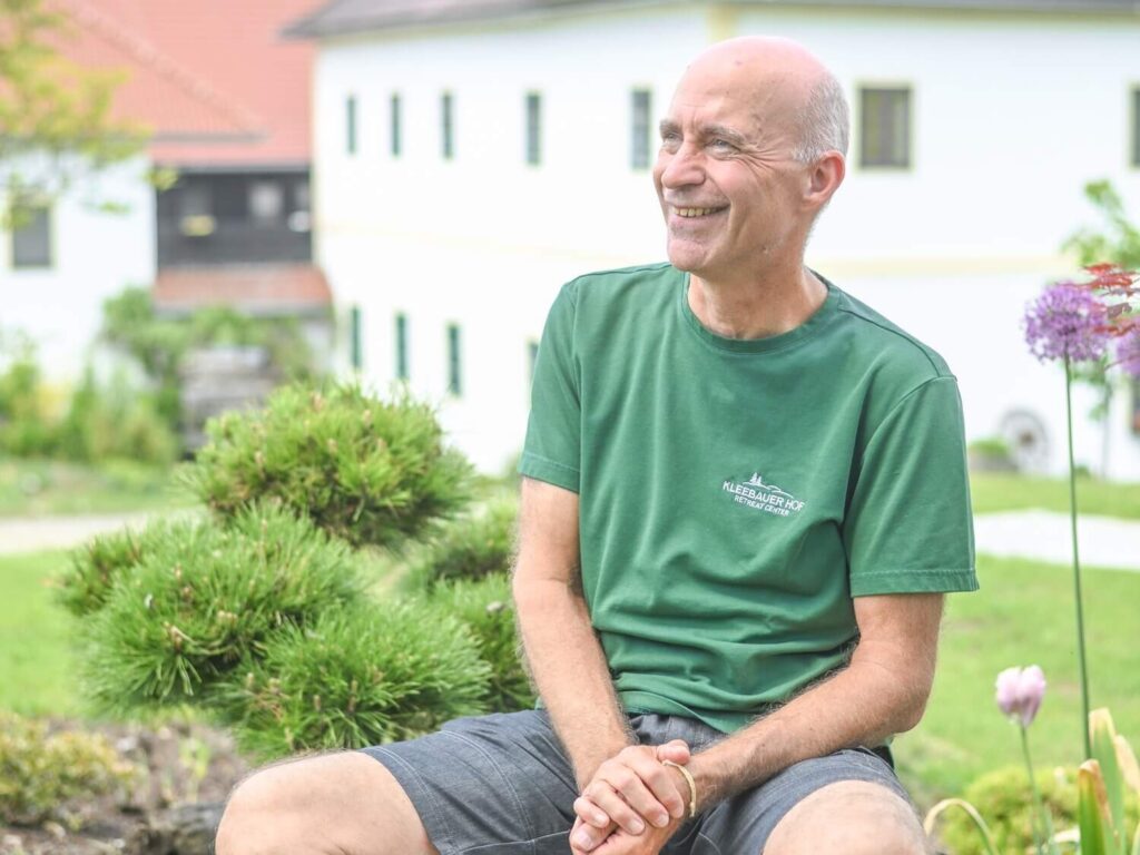 Lächelnder Mann im Garten sitzend
