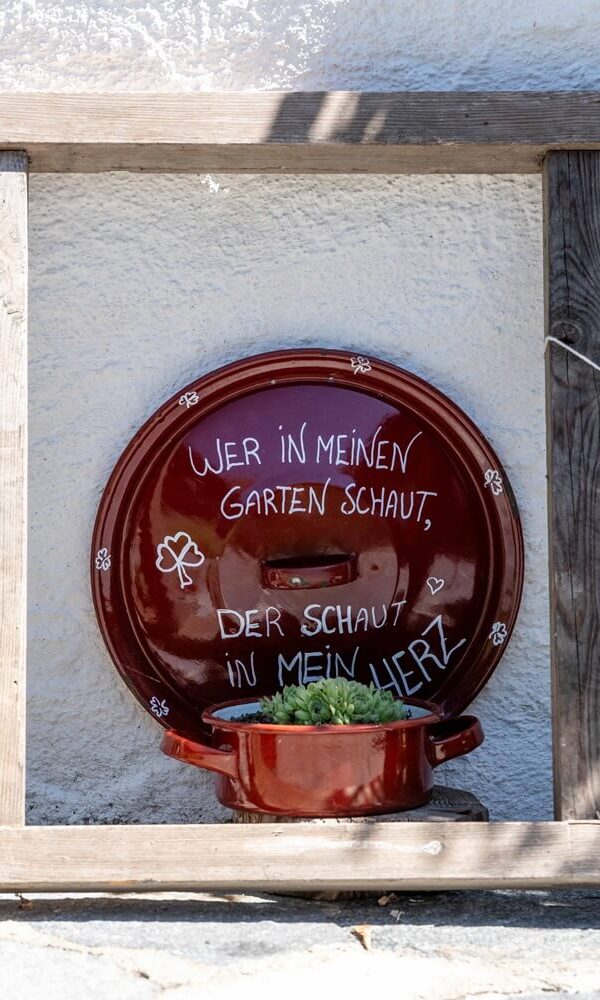 Garten mit dekorativem Topf und Schild