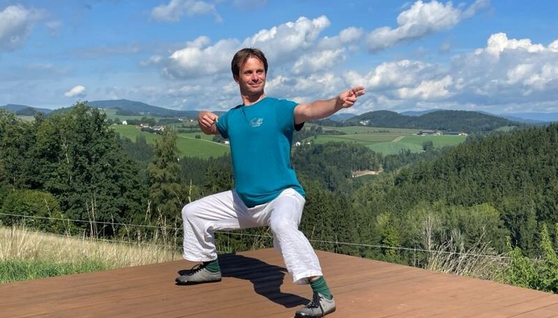 Mann praktiziert Qi Gong im Freien