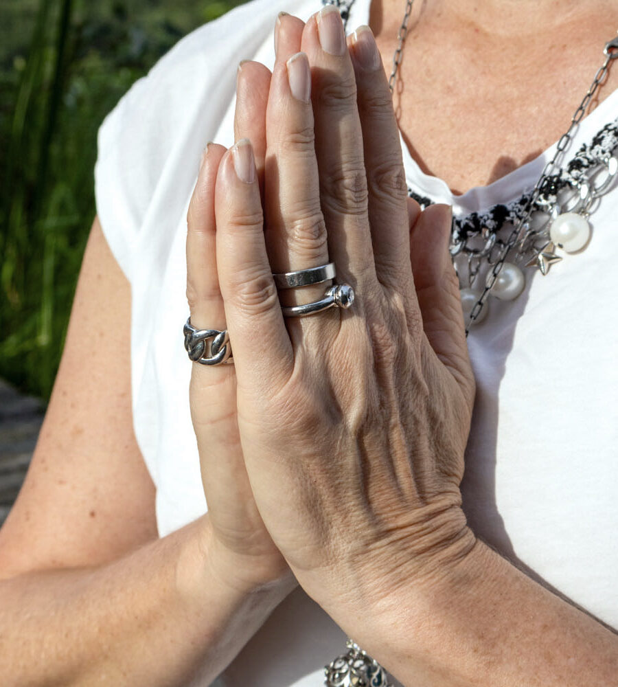 Hände in Gebetshaltung mit Schmuck