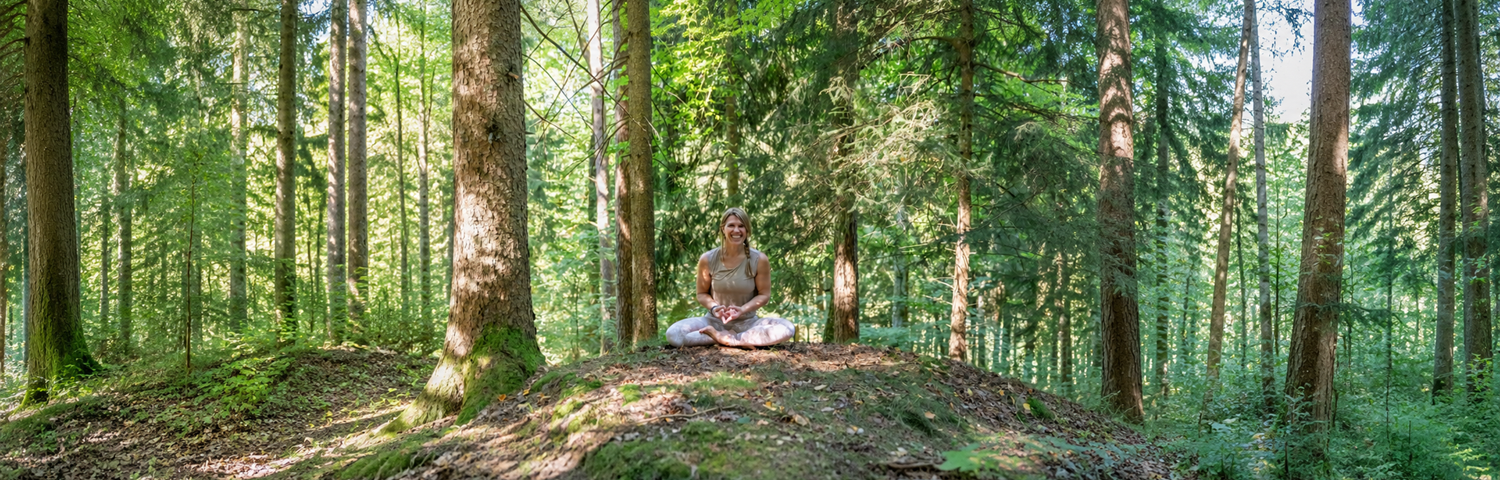 Frau meditiert im Wald