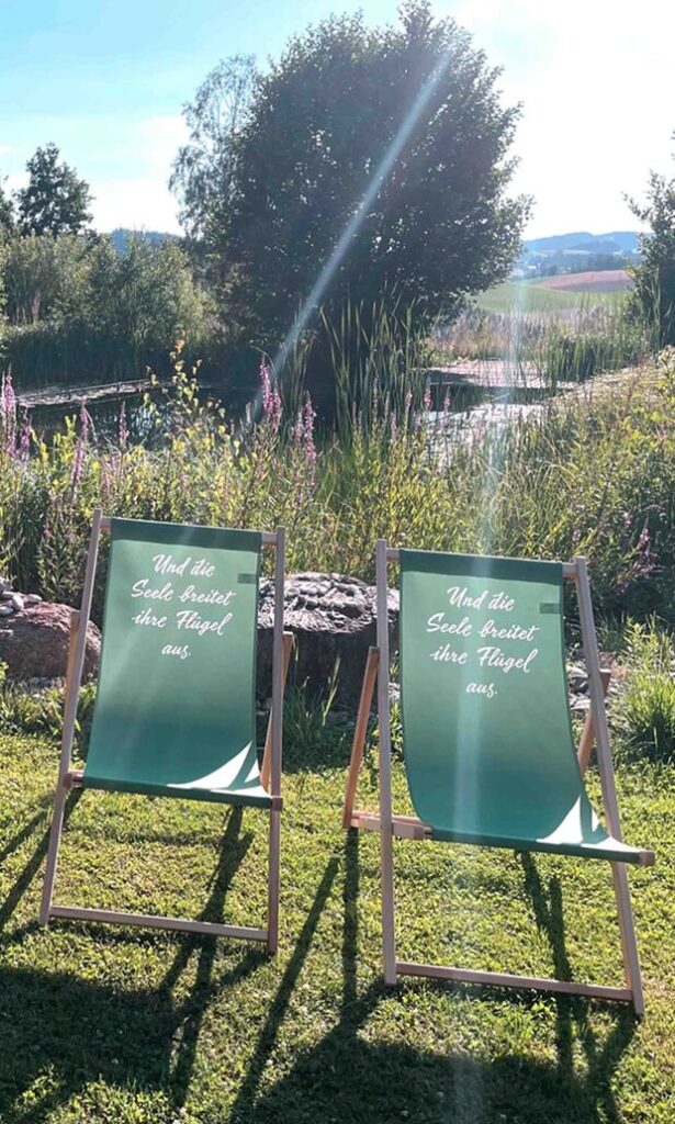 Zwei Liegestühle am Naturbadeteich.