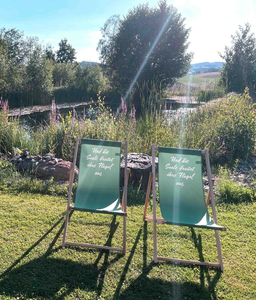 Zwei Liegestühle am Naturbadeteich.