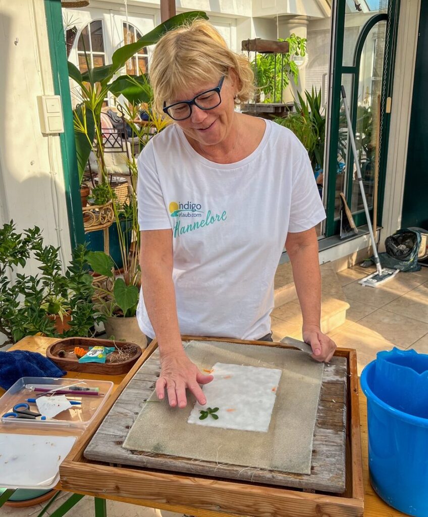 Frau arbeitet mit Pflanzen und Papier.