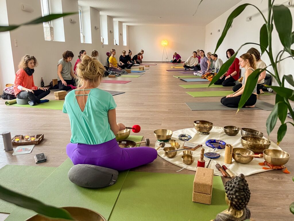 Yoga-Klasse mit Klangschalen und Teilnehmern
