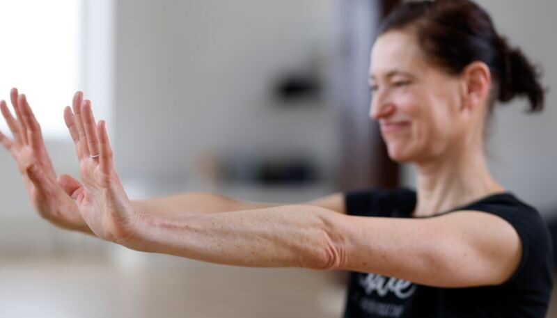 Frau übt Yoga mit ausgestreckten Händen