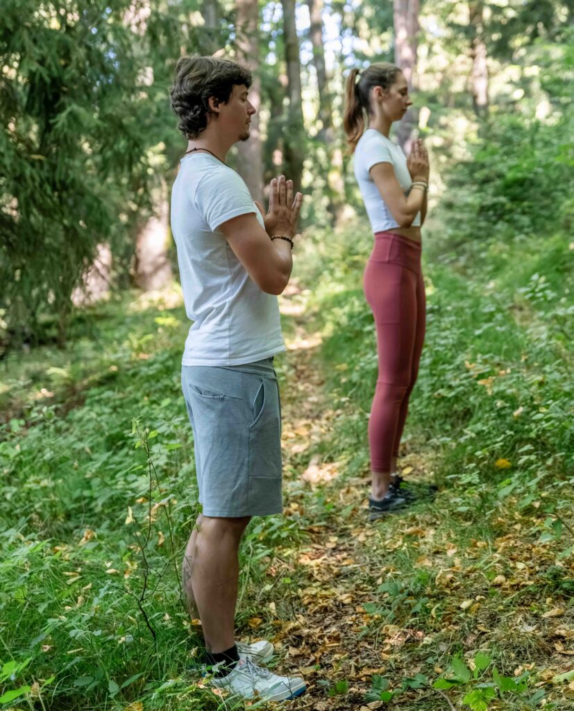 Zwei Personen meditieren im Wald.