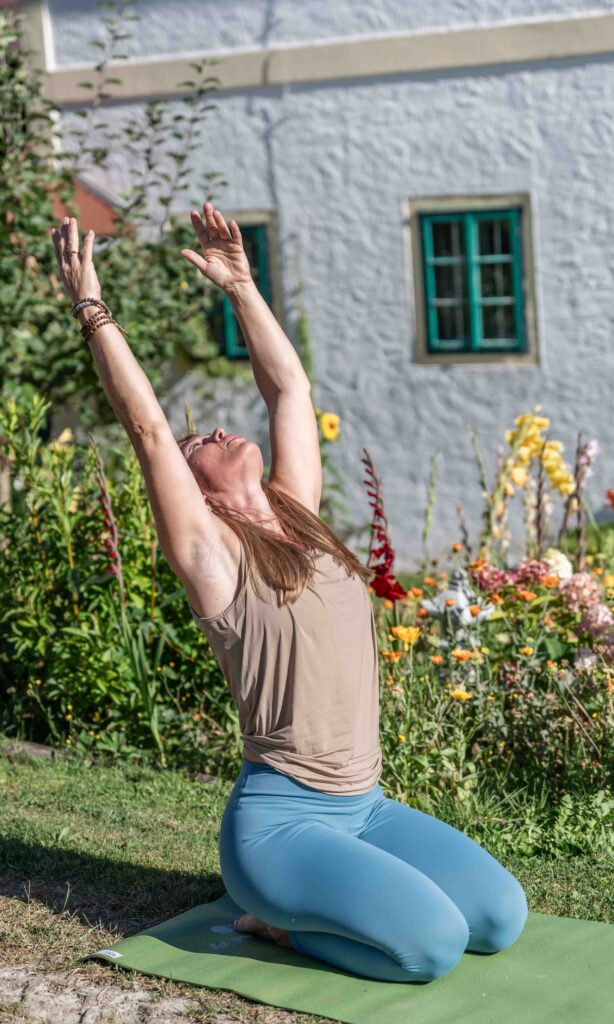 Frau macht Yoga im Garten.
