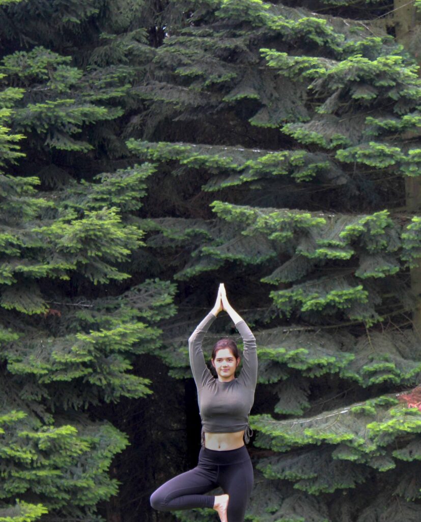 Frau macht Yoga im Wald.